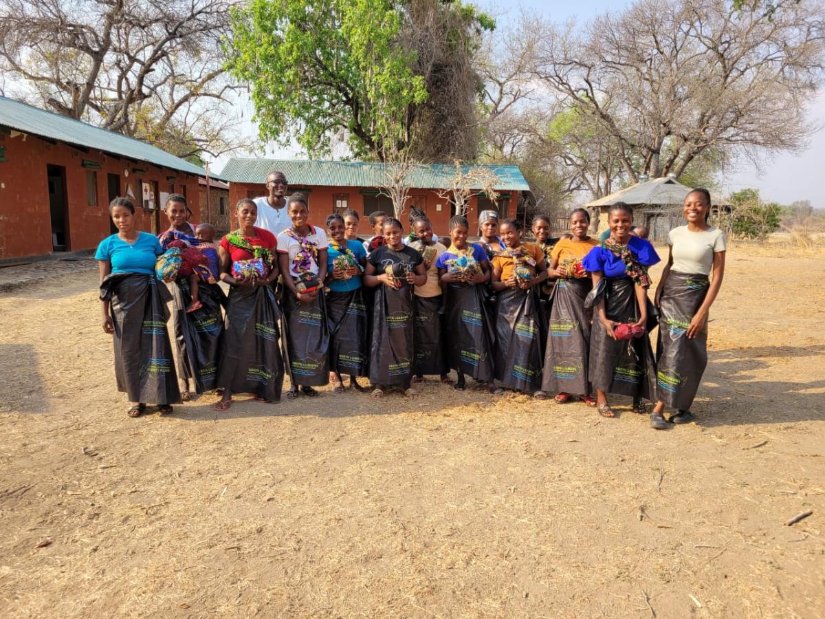 Members of the Tigwilizane women’s group in Mukungule, Zambia stand together outdoors, smiling and supporting one another as they work to strengthen families and protect their landscape. Photo by Evelyn Chalwe – CCO