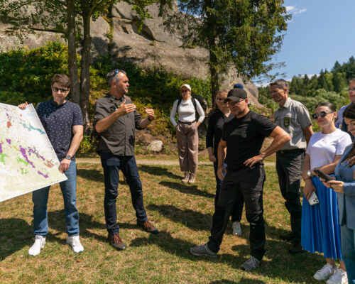 Michael Brombacher explains a map of Skolivski Beskydy National Park to German Environment Minister Carsten Schneider and the visiting delegation.