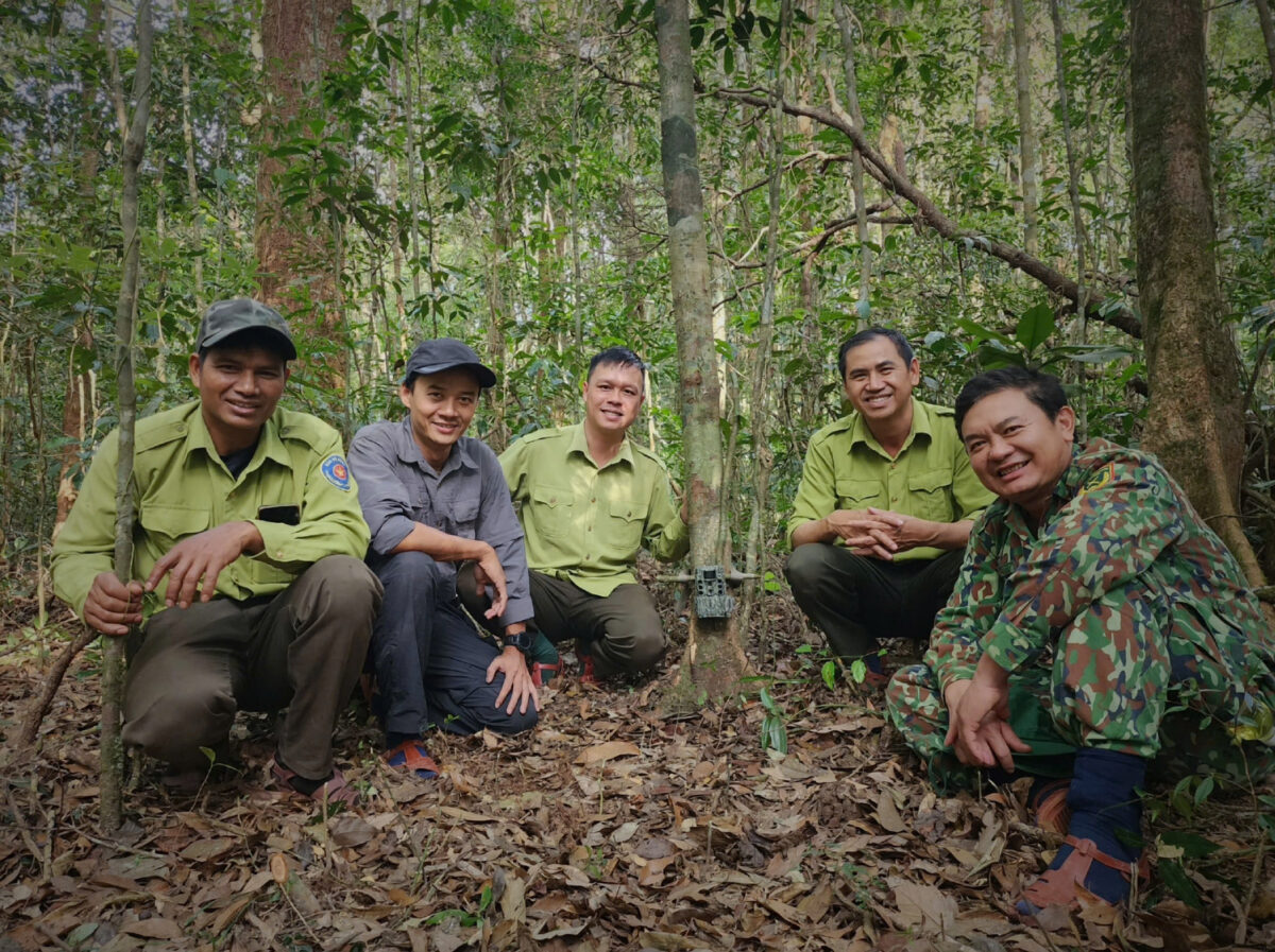 Fünf Mitglieder des Nationalparkteams, der ZGF und des Southern Institute of Ecology neben einer Kamerafalle im Wald des Kon-Ka-Kinh-Nationalparks.
